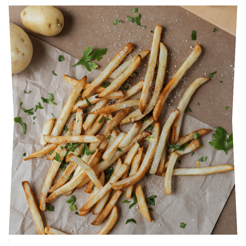 Frites coupés en 8x8 salées et persillées sur une feuille de cuisson